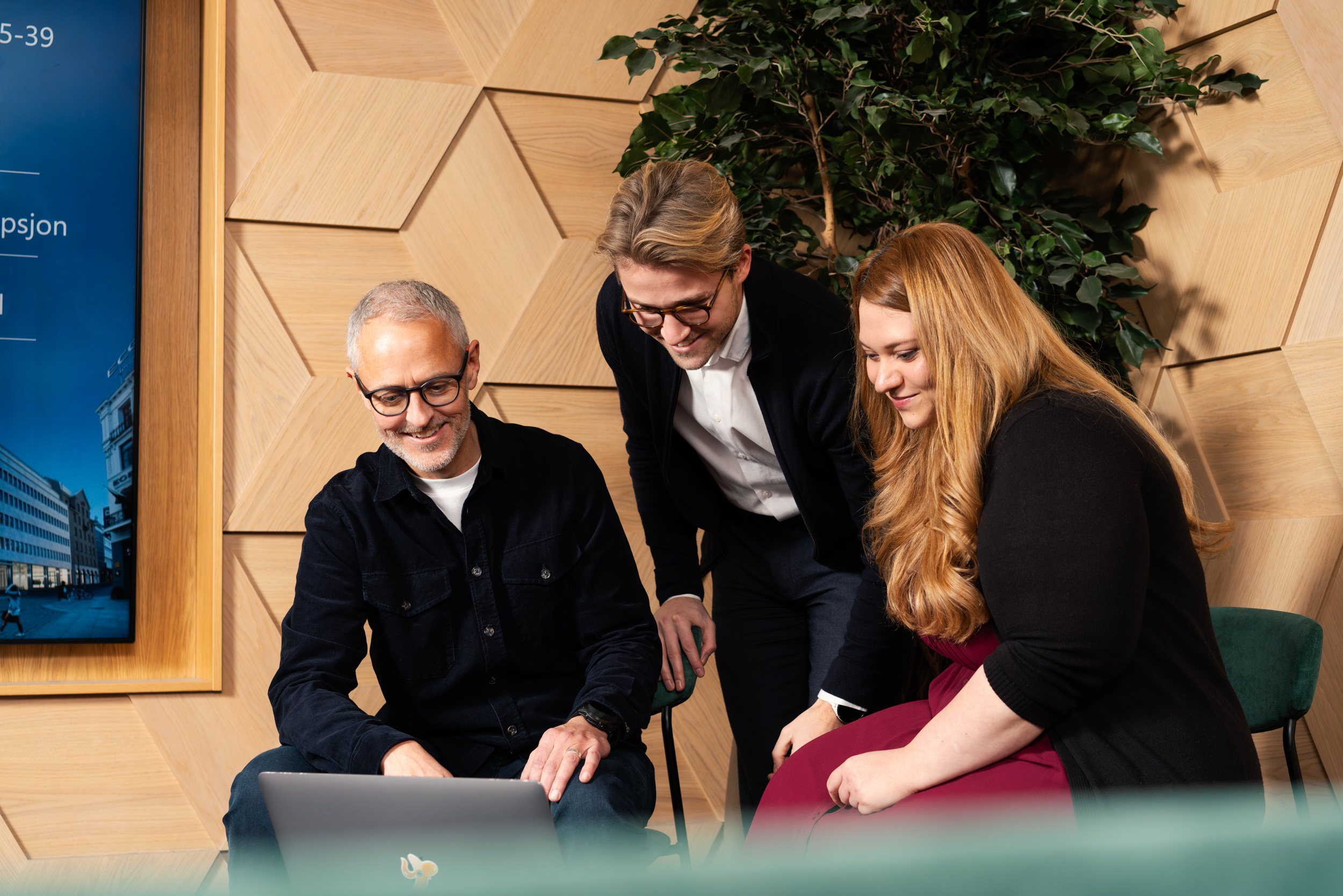 Tre personer ser på en laptop